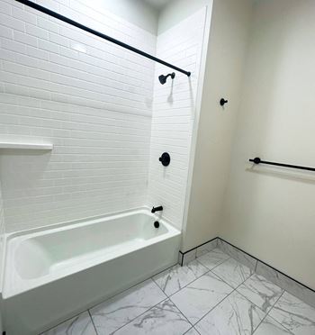 a large white bathroom with a tub and a shower